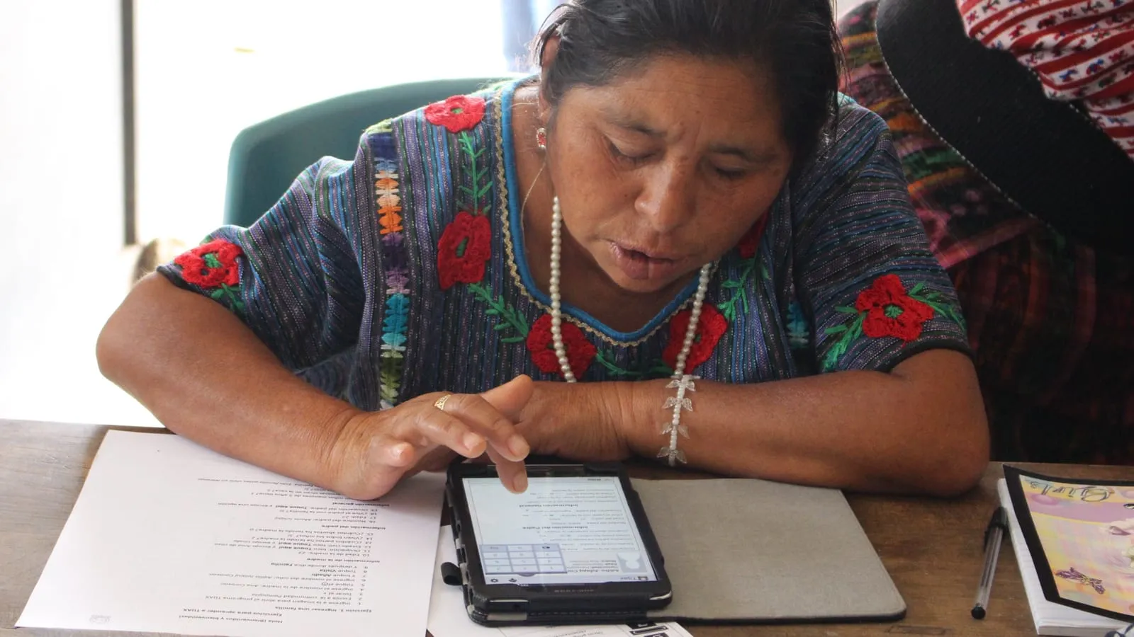Una promotora de salud llenando un formulario en una tableta